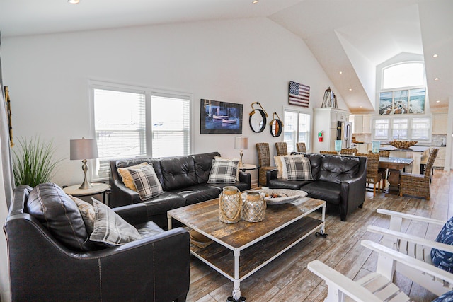 living area featuring plenty of natural light, high vaulted ceiling, wood finished floors, and recessed lighting