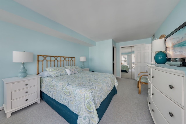 bedroom featuring light colored carpet and a closet