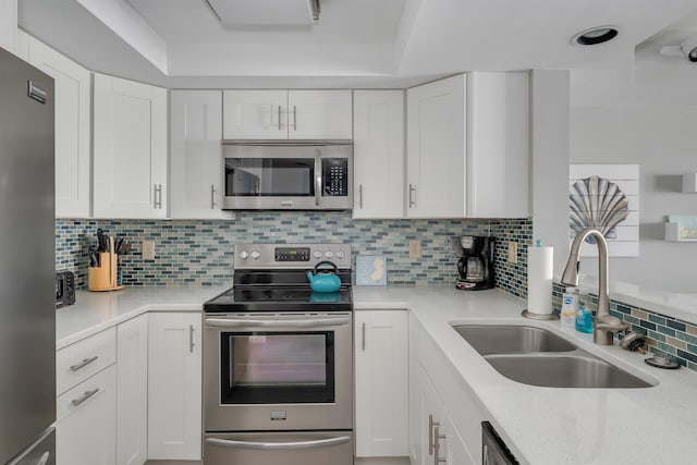 kitchen with white cabinets, appliances with stainless steel finishes, and a sink