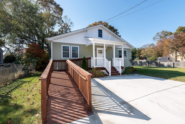 bungalow-style home featuring covered porch and a front yard