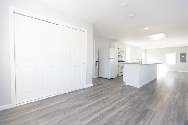 837 Seashore Rd, Lower Township, NJ 08204 - kitchen featuring wood finished floors, white appliances, open floor plan, a center island with sink, and white cabinets
