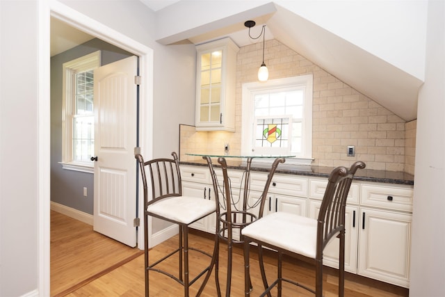 837 Seashore Rd, Lower Township, NJ 08204 - kitchen with light wood-style flooring, white cabinetry, decorative backsplash, lofted ceiling, and glass insert cabinets