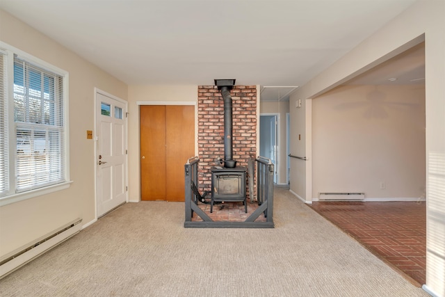 living room with a wood stove and baseboard heating