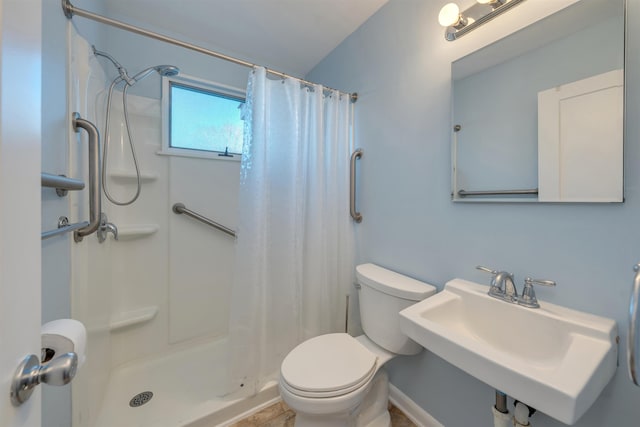 bathroom featuring toilet, curtained shower, and sink