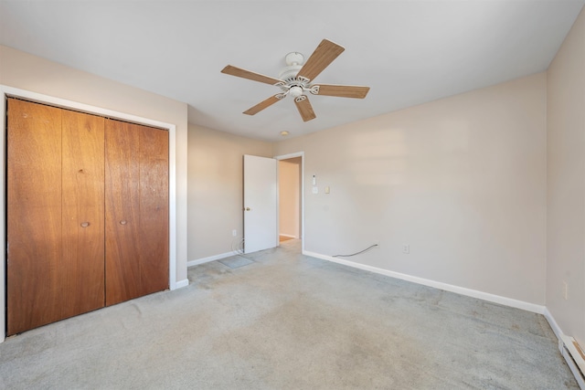 unfurnished bedroom featuring ceiling fan, a closet, light colored carpet, and a baseboard heating unit