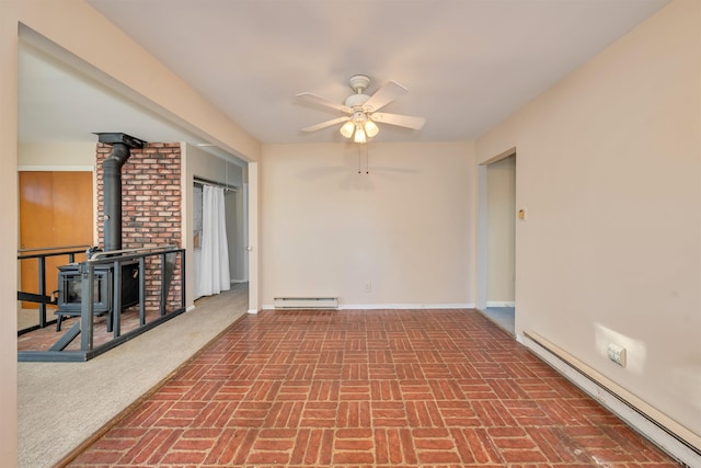 unfurnished living room with ceiling fan and a baseboard heating unit