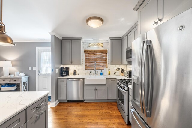 630 21st St Fl 2Nd, Avalon, NJ 08202 - kitchen with stainless steel appliances, gray cabinets, dark wood finished floors, ornamental molding, and tasteful backsplash