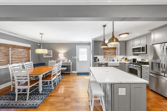 630 21st St Fl 2Nd, Avalon, NJ 08202 - kitchen featuring gray cabinetry, stainless steel appliances, a center island, crown molding, and hardwood / wood-style flooring