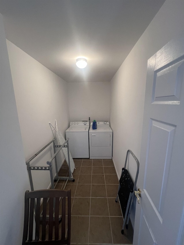 laundry room with dark tile patterned floors and separate washer and dryer