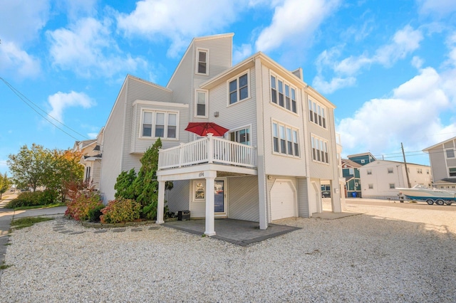 rear view of house featuring a balcony and a garage