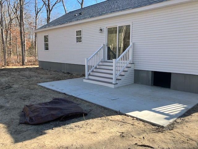 rear view of house featuring entry steps, a patio area, and roof with shingles