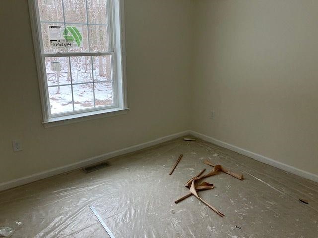 spare room with baseboards and visible vents