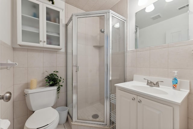 bathroom with walk in shower, toilet, and tile walls