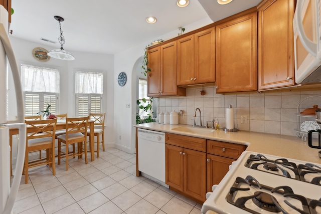 kitchen with sink, decorative light fixtures, white appliances, decorative backsplash, and light tile patterned floors