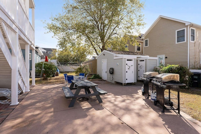 view of patio with area for grilling and a storage shed