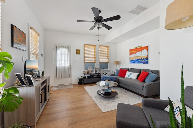 living room featuring light hardwood / wood-style flooring and ceiling fan