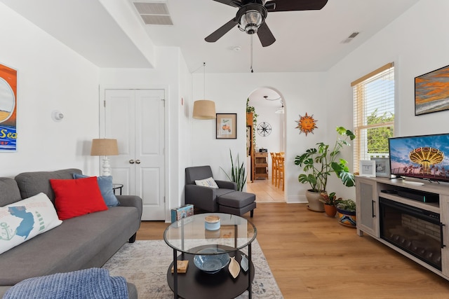 living room with light hardwood / wood-style flooring and ceiling fan