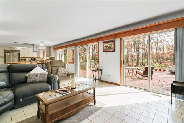 living area featuring light tile patterned flooring, plenty of natural light, and visible vents