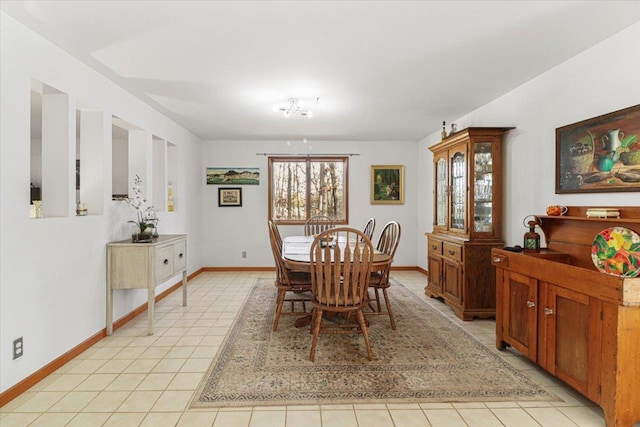 dining space with light tile patterned floors and baseboards