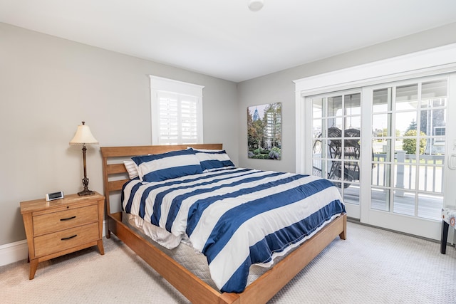 bedroom featuring light carpet, access to outside, and baseboards