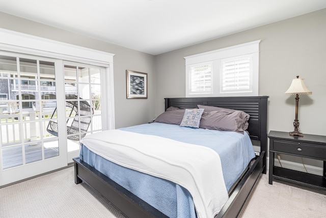 bedroom with baseboards, light colored carpet, and access to exterior