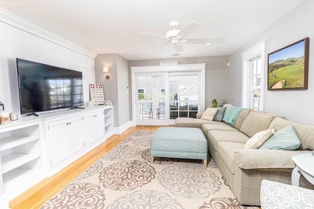 living room with ceiling fan and light wood finished floors