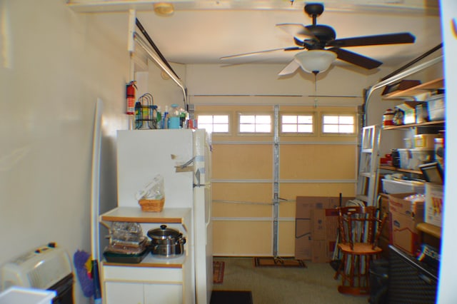 garage with a ceiling fan and freestanding refrigerator