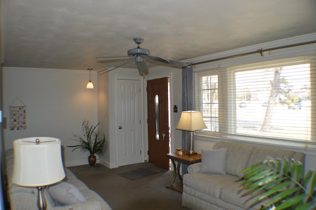 living room featuring carpet floors, crown molding, baseboards, and ceiling fan