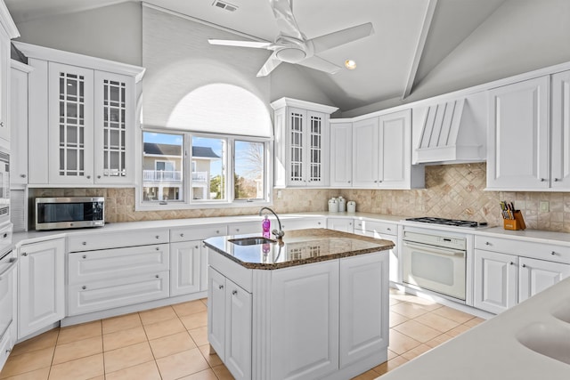 kitchen featuring light tile patterned floors, a sink, white appliances, and lofted ceiling
