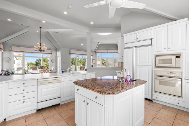 kitchen featuring built in appliances, lofted ceiling, and light tile patterned floors