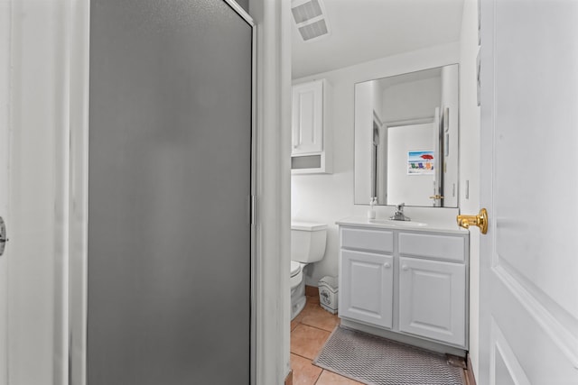bathroom featuring a shower stall, vanity, tile patterned flooring, visible vents, and toilet