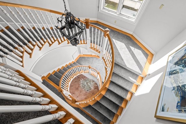 stairs with baseboards and an inviting chandelier