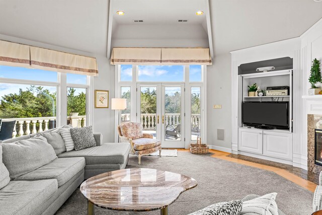living room featuring plenty of natural light, a towering ceiling, and visible vents