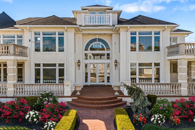exterior space featuring french doors, a balcony, and stucco siding
