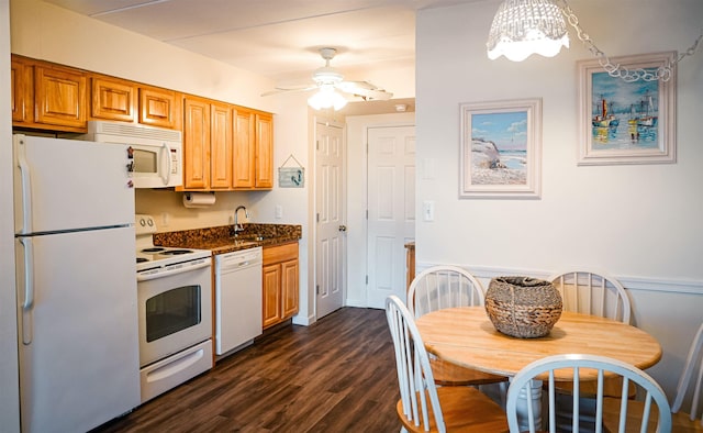 kitchen featuring ceiling fan, white appliances, dark wood-type flooring, a sink, and dark countertops