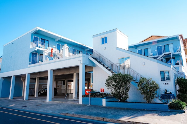 exterior space featuring covered parking and stairs