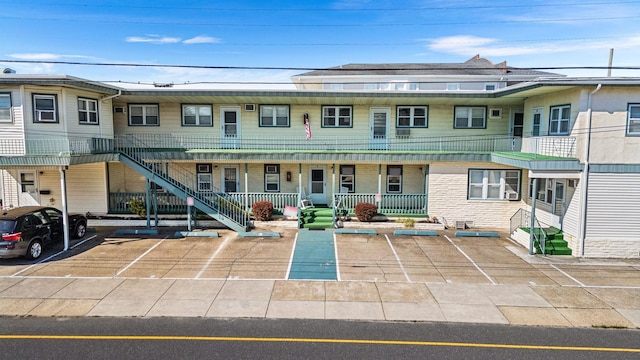 view of front of property featuring uncovered parking, a porch, and brick siding