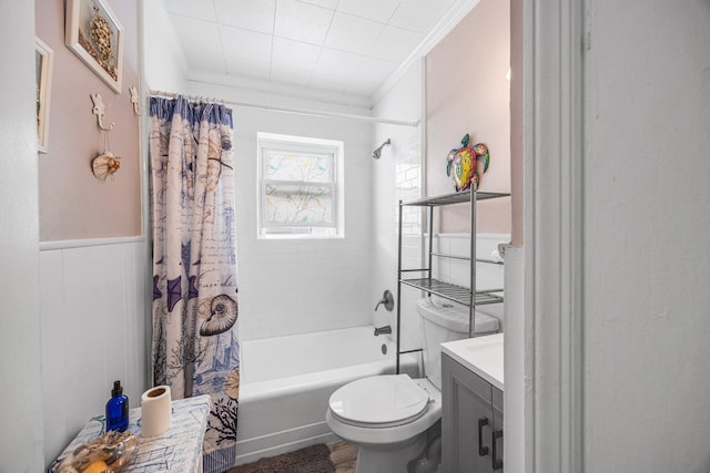 bathroom featuring crown molding, toilet, wainscoting, shower / bathtub combination with curtain, and vanity