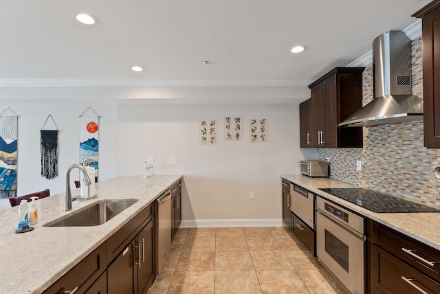 kitchen featuring backsplash, wall chimney range hood, sink, light stone countertops, and appliances with stainless steel finishes