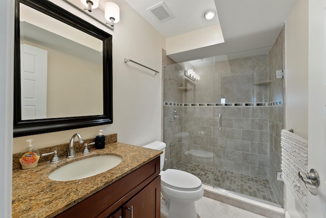 bathroom featuring tile patterned flooring, vanity, toilet, and an enclosed shower