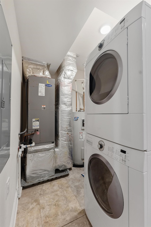 laundry room with electric water heater and stacked washer and clothes dryer