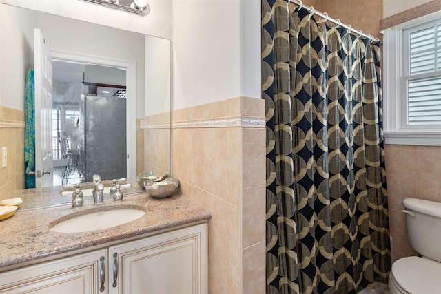 bathroom featuring vanity, toilet, tile walls, and walk in shower