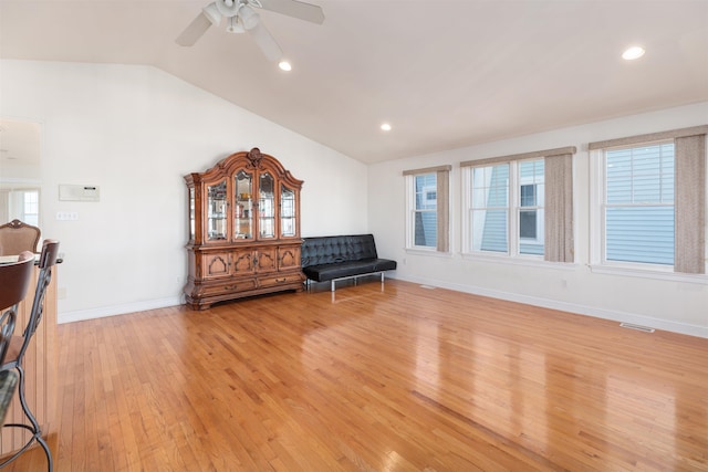 sitting room featuring a wealth of natural light, ceiling fan, lofted ceiling, and light wood-type flooring