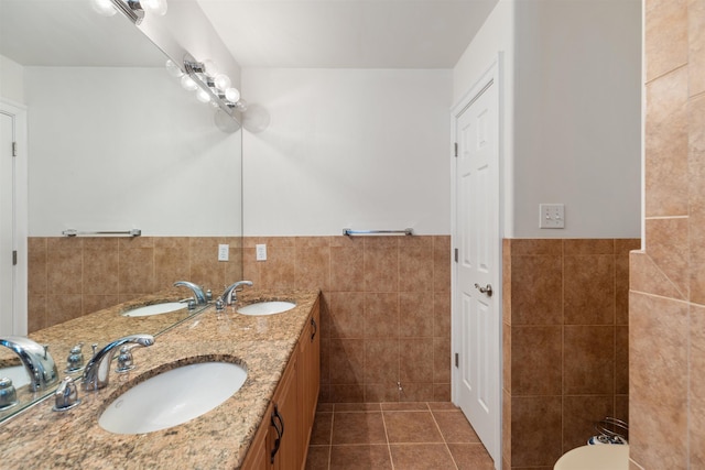 bathroom featuring tile patterned flooring, vanity, and tile walls