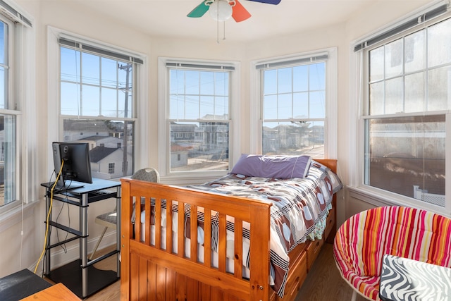 bedroom with multiple windows, ceiling fan, and hardwood / wood-style floors