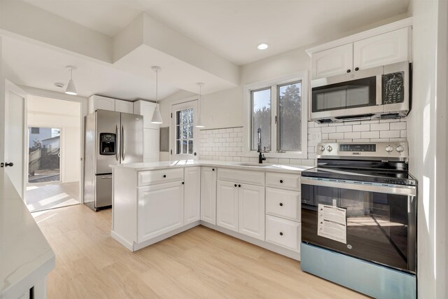 715 Eldredge Ave, North Cape May, NJ 08204 - kitchen featuring decorative backsplash, a sink, light wood-style floors, stainless steel appliances, and white cabinetry