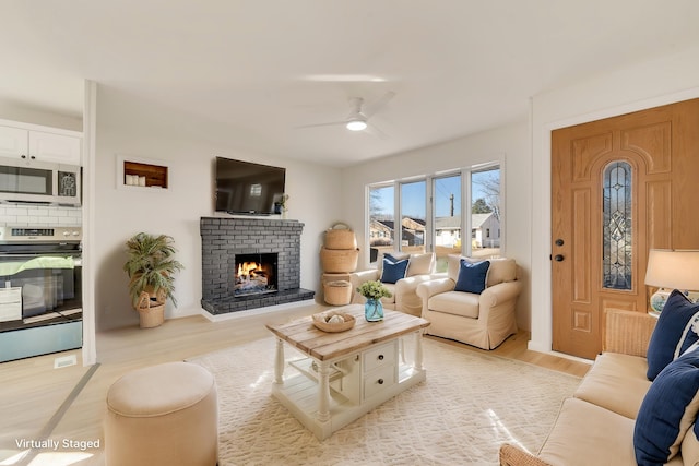715 Eldredge Ave, North Cape May, NJ 08204 - living room with light wood-type flooring, a brick fireplace, and ceiling fan
