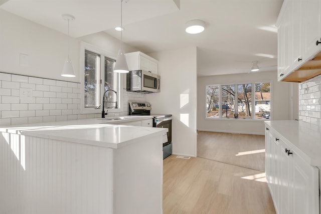 715 Eldredge Ave, North Cape May, NJ 08204 - kitchen with appliances with stainless steel finishes, a sink, light countertops, white cabinetry, and backsplash