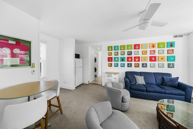 127 34th St, Avalon, NJ 08202 - living room featuring stacked washer / dryer, carpet floors, a ceiling fan, and baseboards