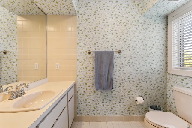 bathroom with toilet, vanity, and tile patterned floors